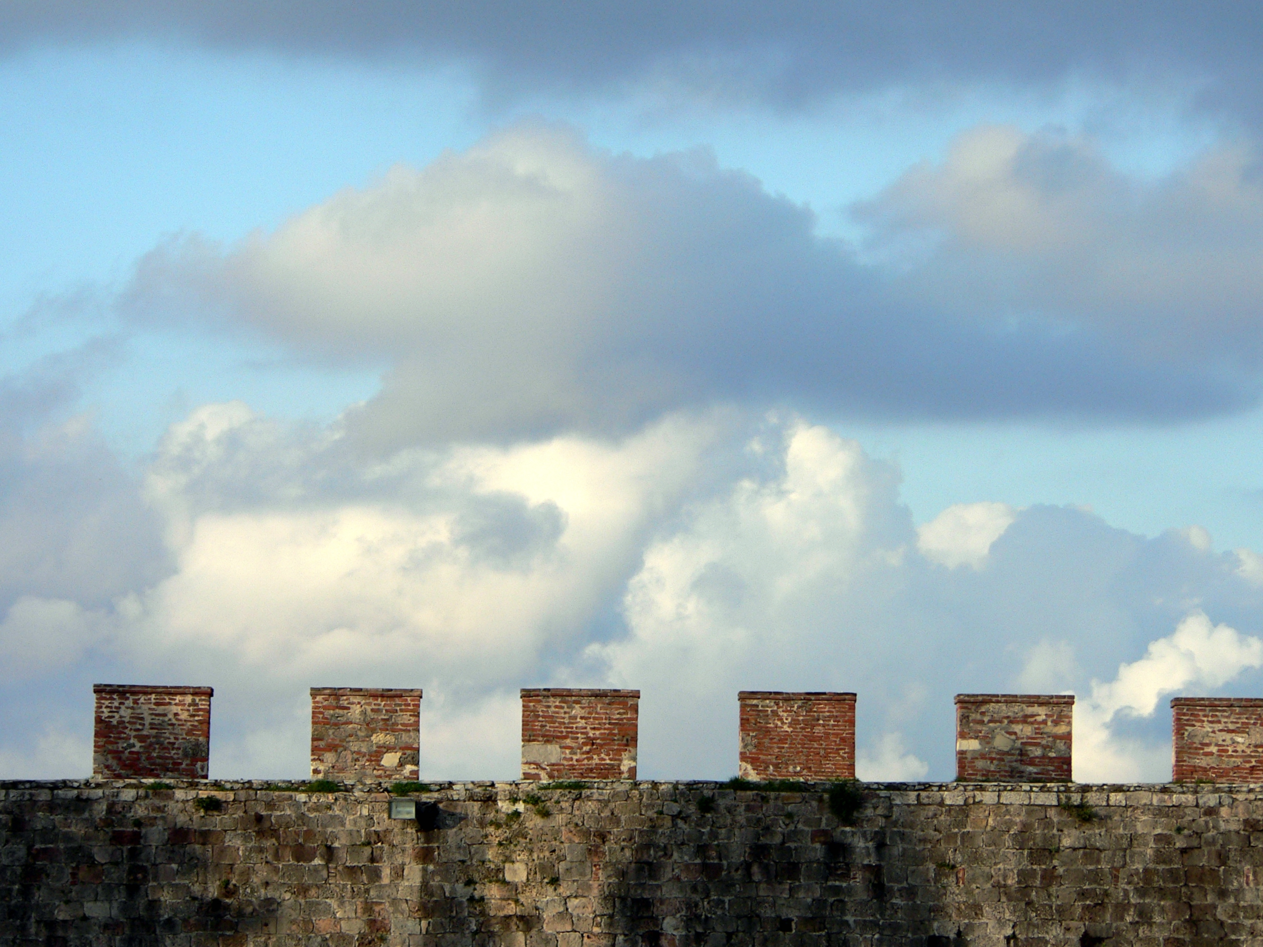 A castle wall and blue sky beyond